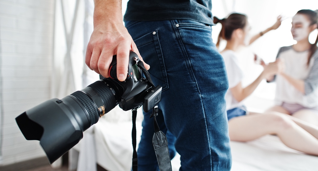 Photographer shooting hands close up with dslr camera and model posing on background at studio.